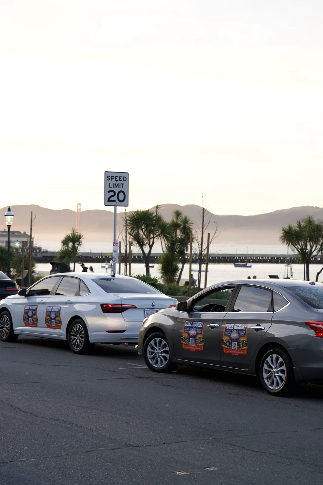 Two Complex “Come Hungry” campaign cars parked on the San Francisco waterfront