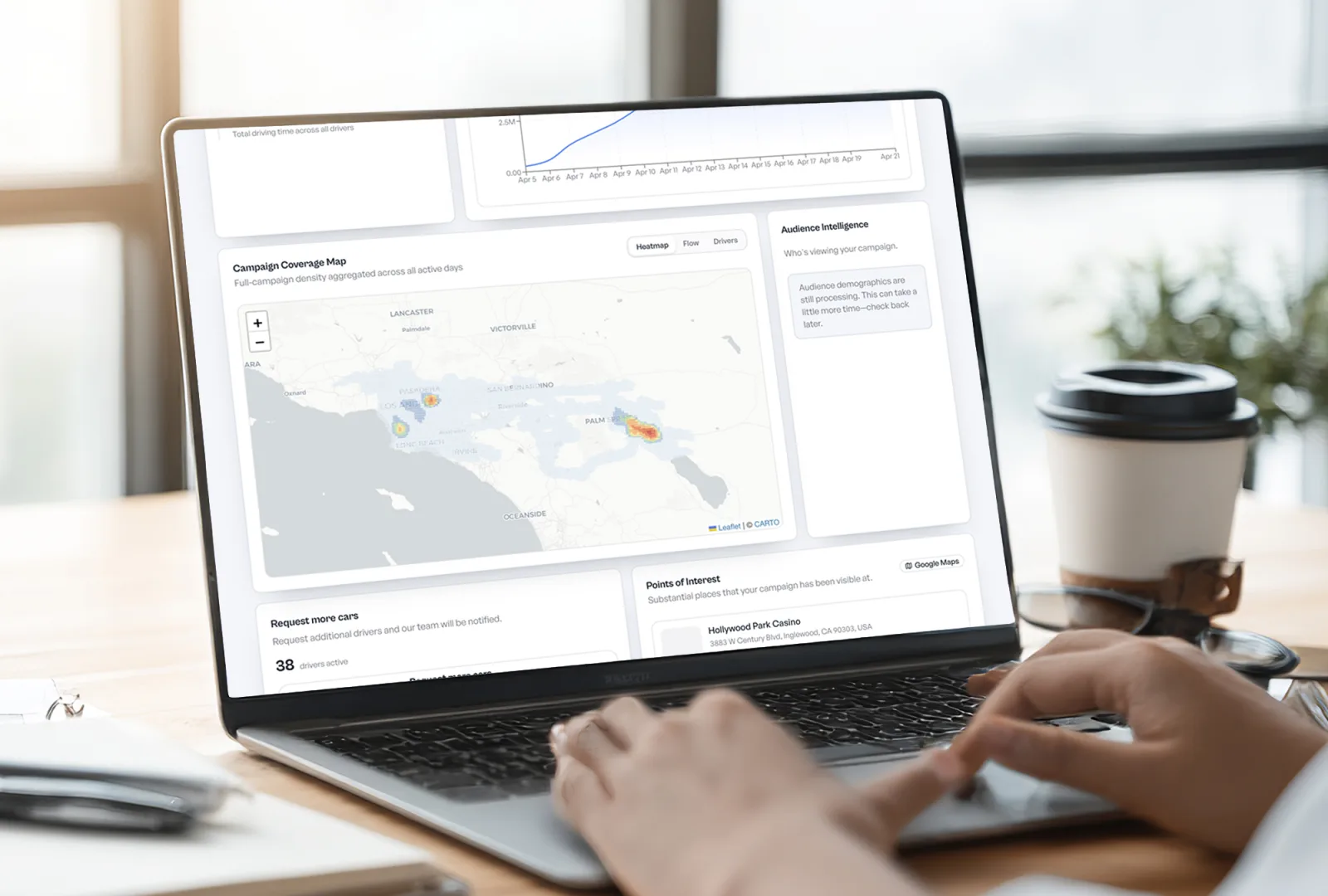 Laptop showing the Stic campaign overview dashboard with impressions, performance charts, and a coverage map